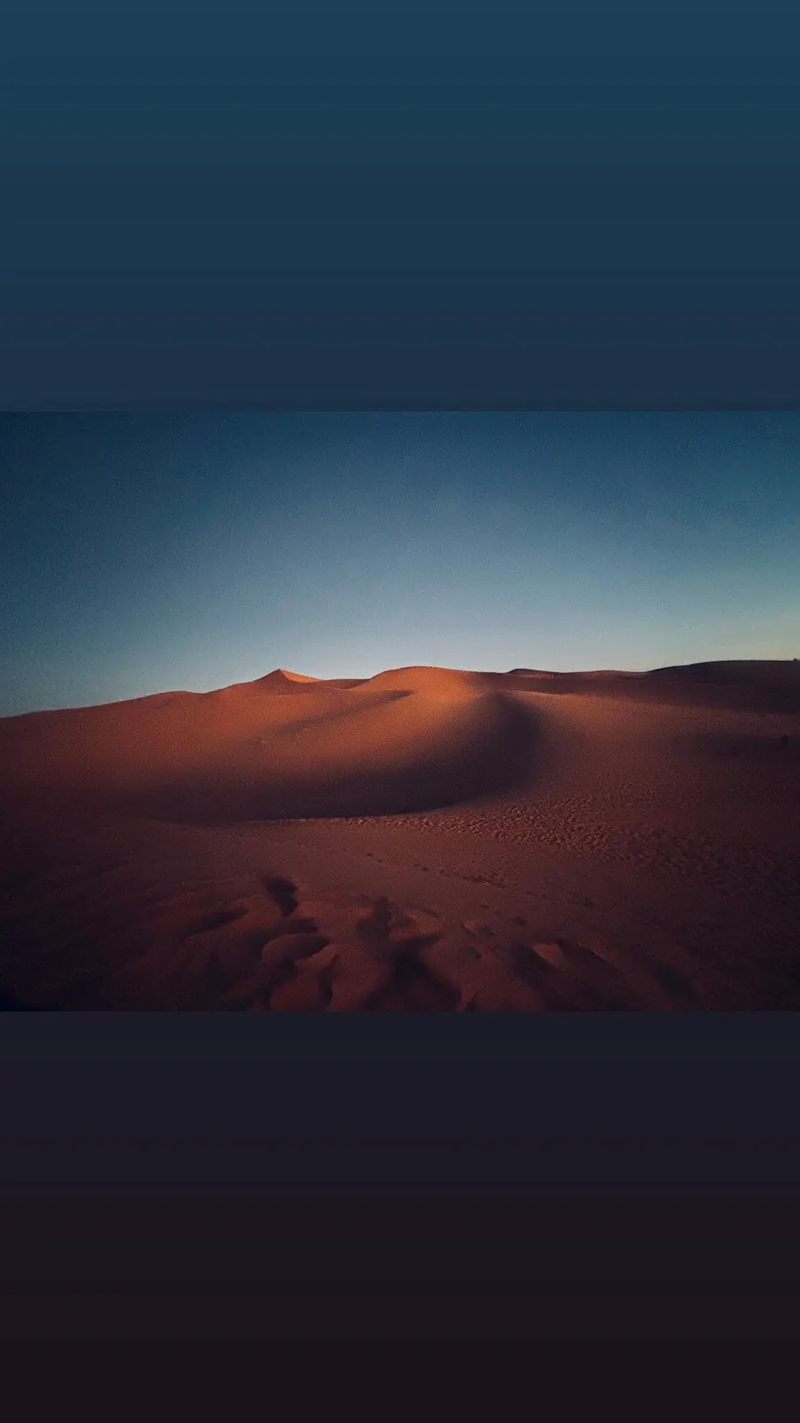 Sahara dunes at twilight, deep blue sky above