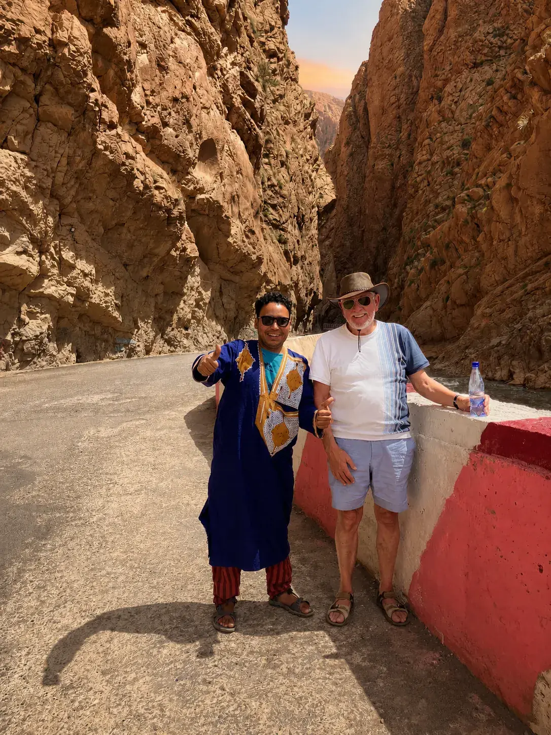 Guide and traveller walking through the Todra Gorge canyon