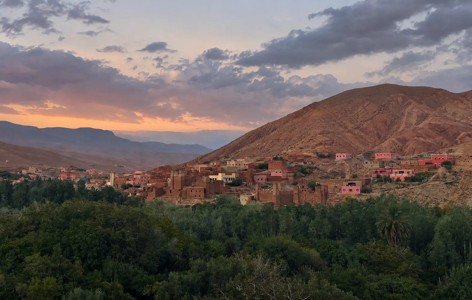 Dades Valley village at sunset beneath a pink and purple sky