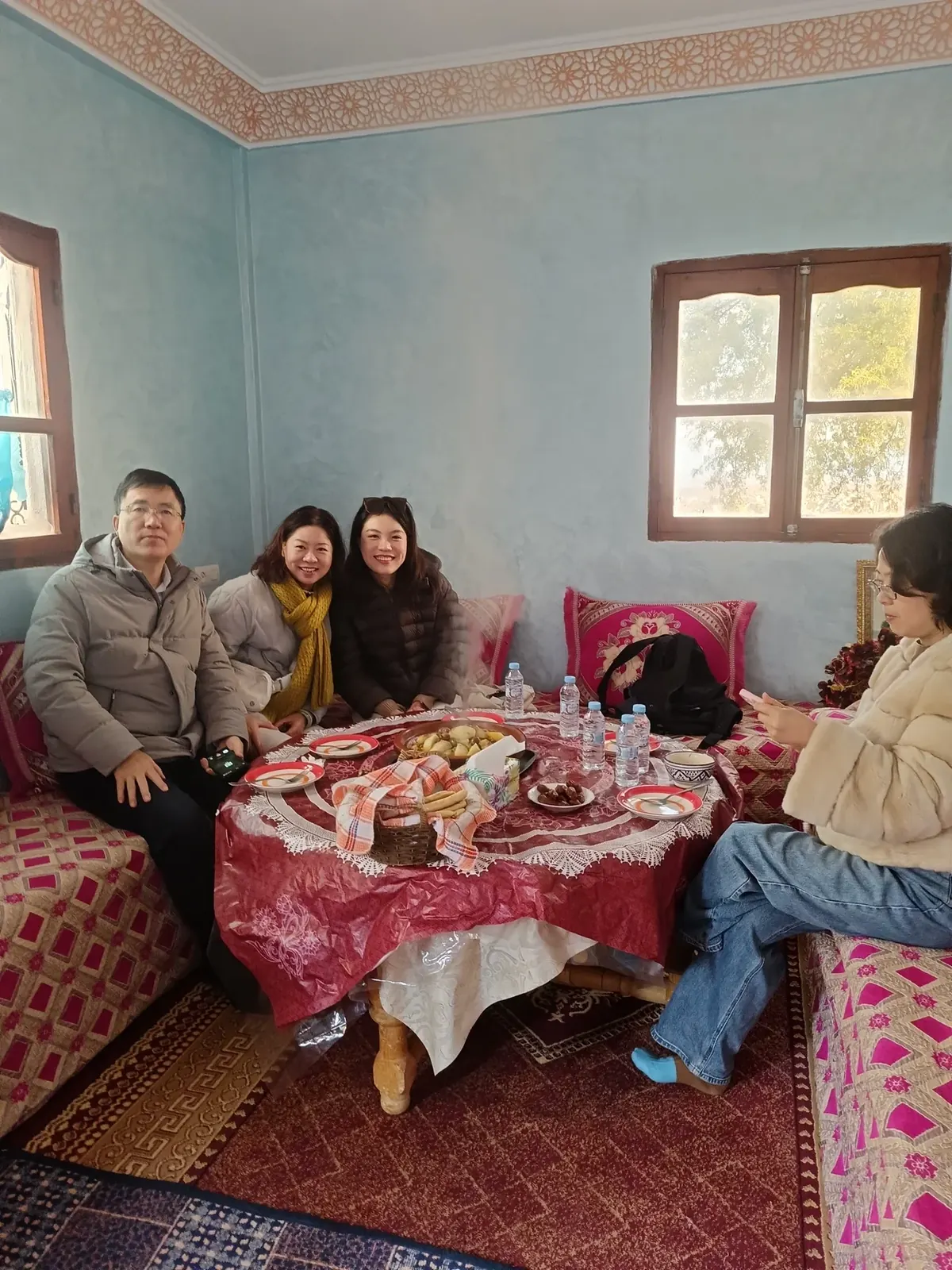 Family and guests sharing a home-cooked Moroccan meal around the table